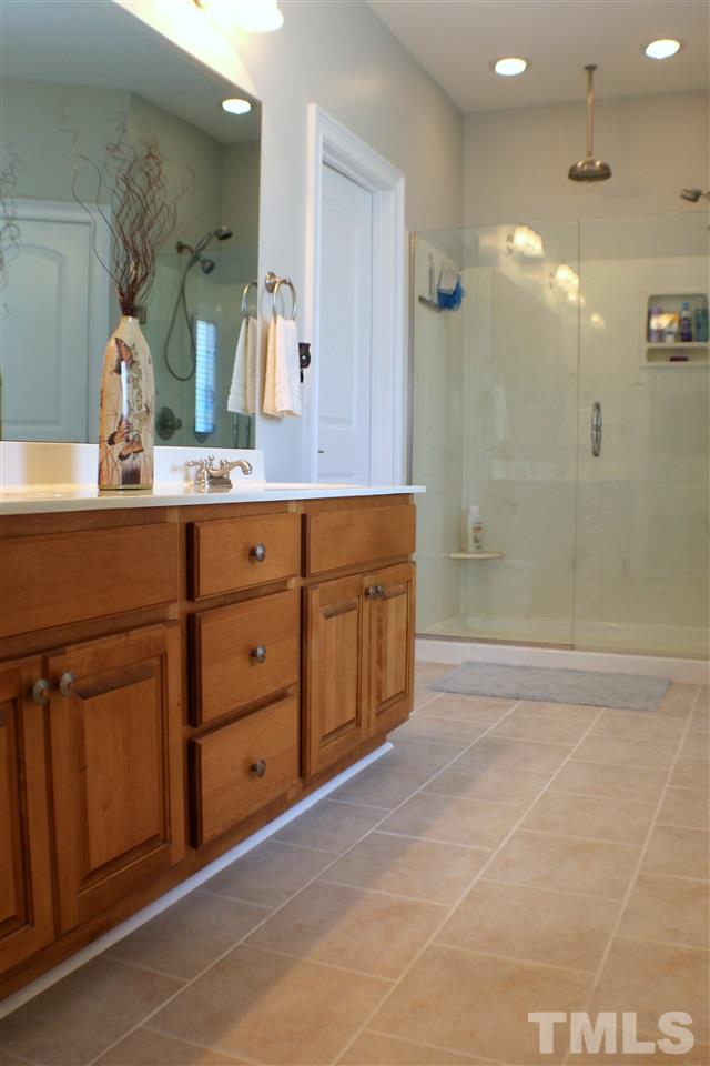 820 Hood Farm Road Clayton, NC 27520 - Photo 7 of 20 This custom Master Bath features brand new TILE FLOORING, double vanity, GARDEN TUB, 22-inch mirrored TV with amplifier system, & WALK IN CLOSET with organization system.