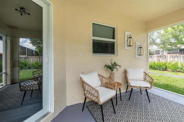 a view of a porch with chairs and backyard