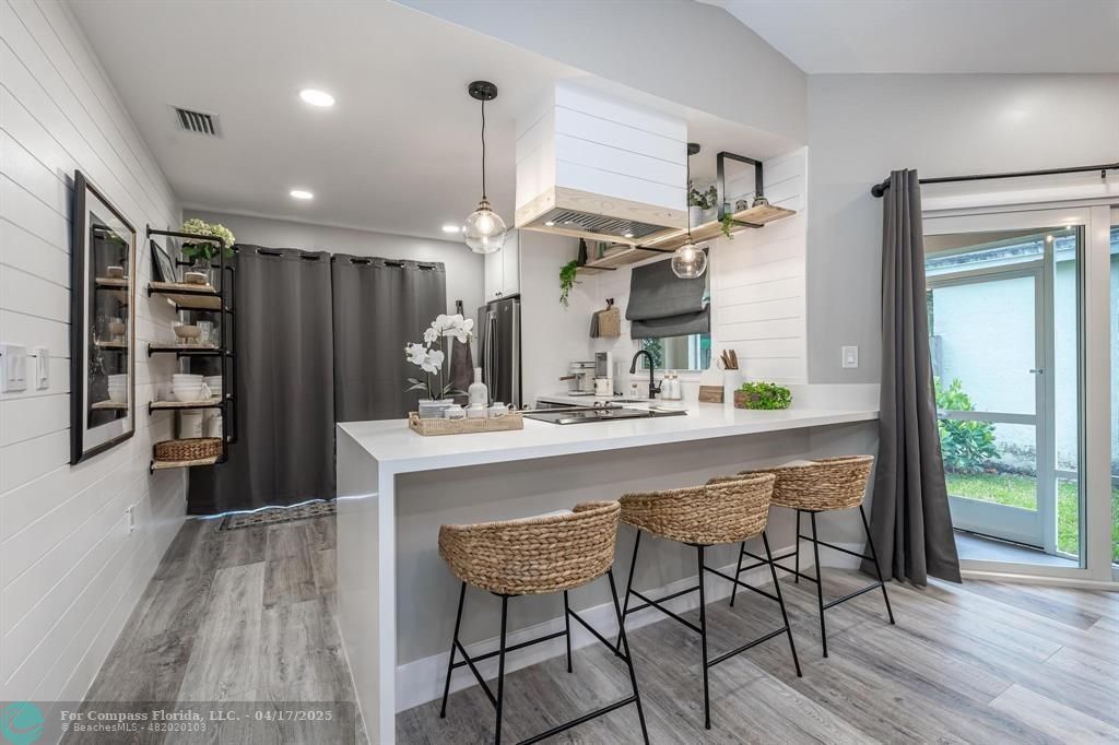 Undisclosed Address Davie, FL 33314 - Photo 3 of 23 a kitchen with kitchen island a dining table chairs cabinets and wooden floor
