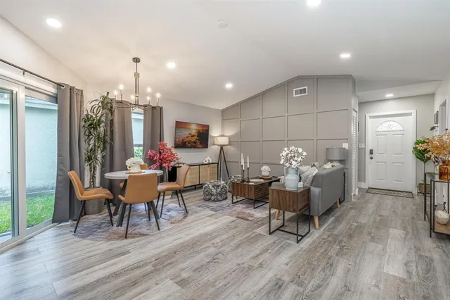 a living room with furniture and a dining table with wooden floor