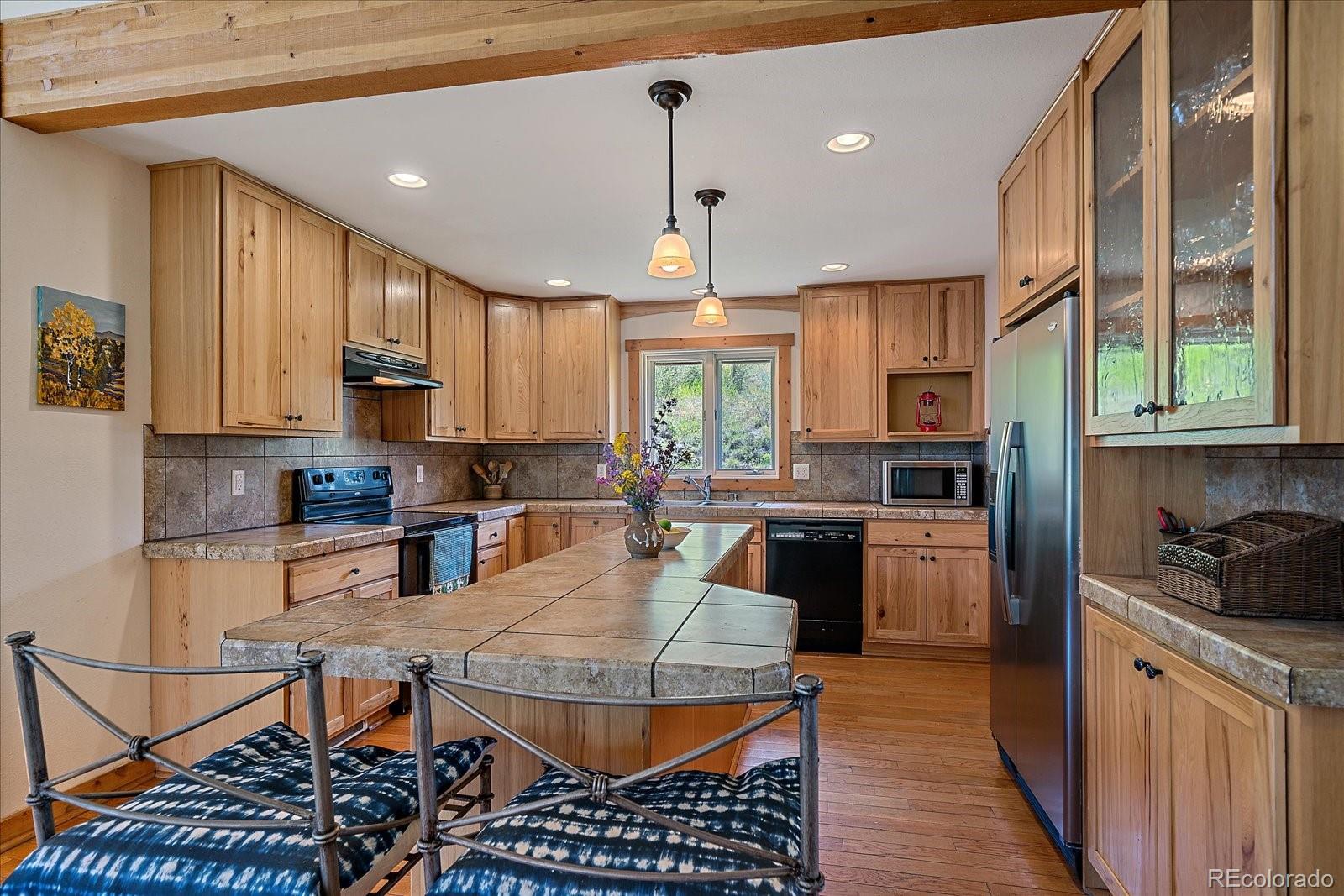 14482 Jubilee Trail Pine, CO 80470 - Photo 20 of 40 a kitchen with stainless steel appliances granite countertop a stove top oven a sink dishwasher and cabinets with wooden floor