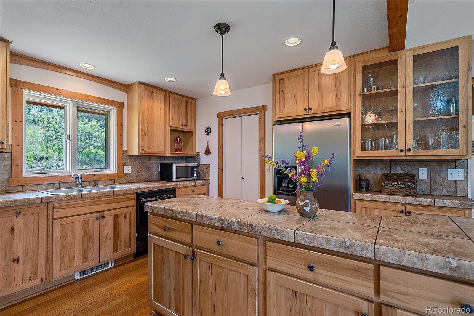 14482 Jubilee Trail Pine, CO 80470 - Photo 21 of 40 a kitchen with stainless steel appliances granite countertop a sink and wooden cabinets
