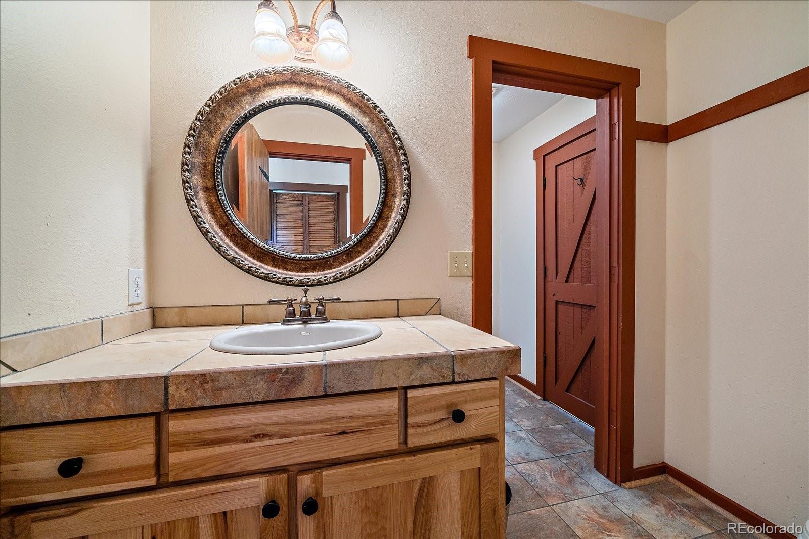 14482 Jubilee Trail Pine, CO 80470 - Photo 25 of 40 a bathroom with a sink and a mirror