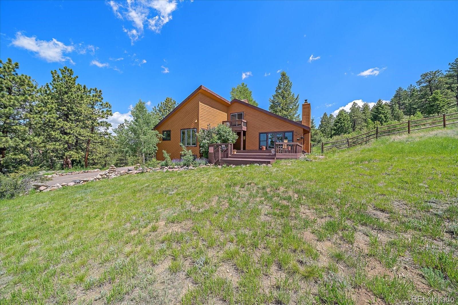 14482 Jubilee Trail Pine, CO 80470 - Photo 3 of 40 a front view of a house with a yard