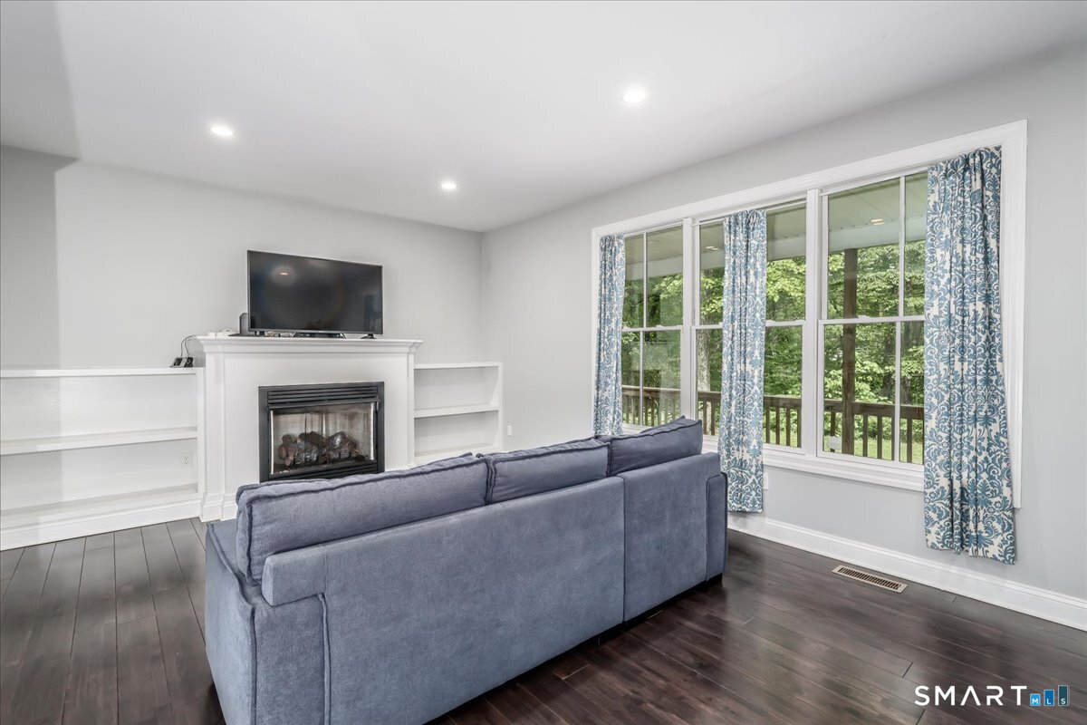 127 Putnam Park Road Bethel, CT 06801 - Photo 7 of 35 a living room with furniture a flat screen tv and a fireplace