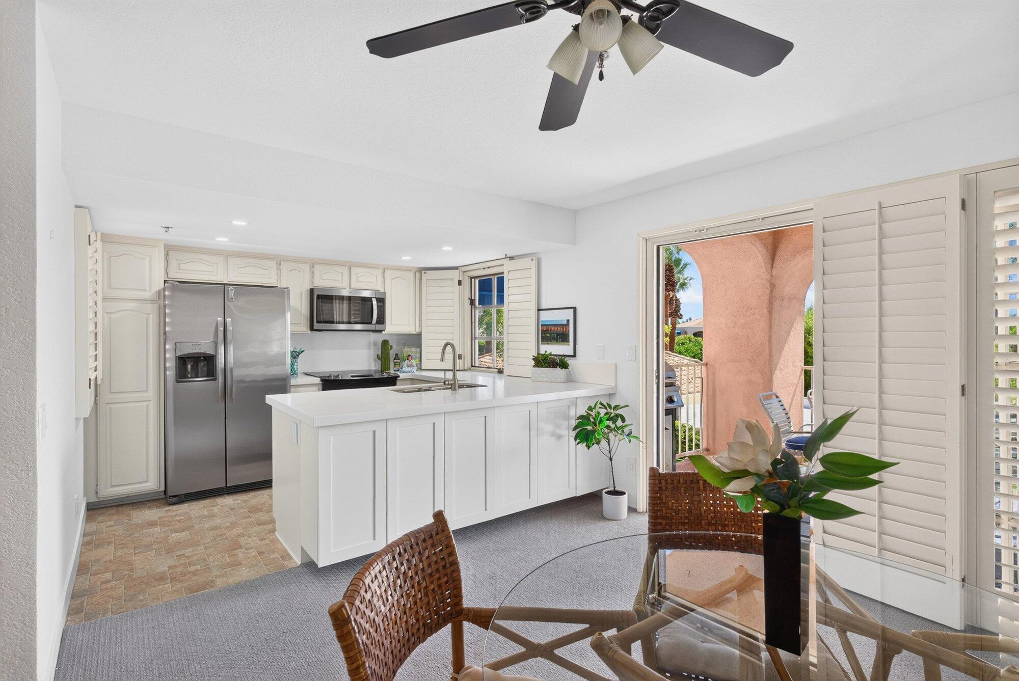 500 East Amado Road, Unit 313 Palm Springs, CA 92262 - Photo 5 of 32 a kitchen with stainless steel appliances a table and chairs in it