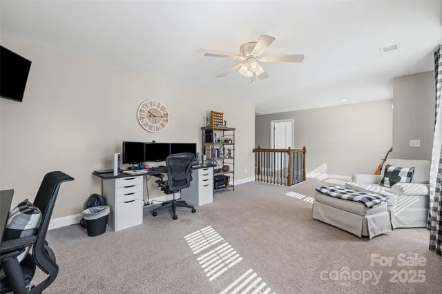 a living room with furniture a flat screen tv and kitchen view