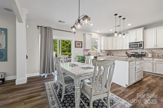 a kitchen with stainless steel appliances kitchen island granite countertop a stove a sink and a refrigerator