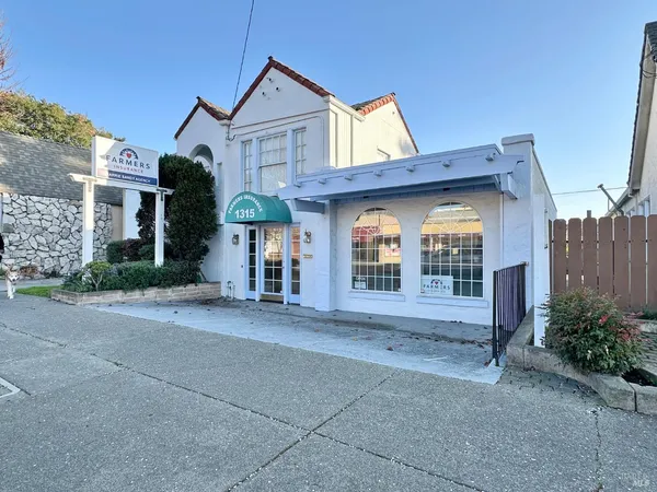 a view of a house with a yard and potted plants