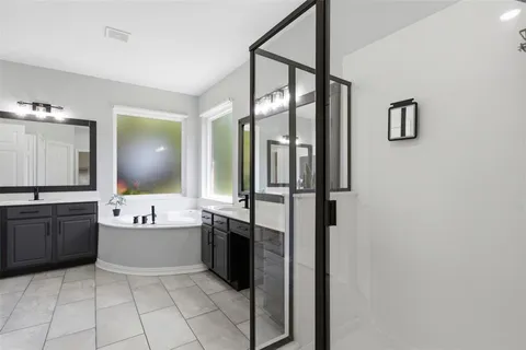 a bathroom with a tub sink and mirror