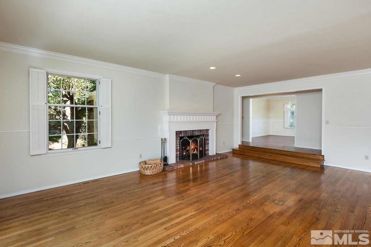 2512 Lake Ridge Shores Circle Reno, NV 89519 - Photo 8 of 25 an empty room with wooden floor fireplace and windows