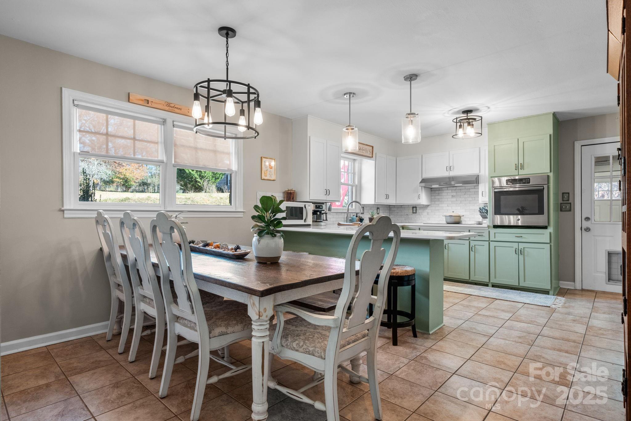 631 Powell Road Northeast Lenoir, NC 28645 - Photo 21 of 38 a kitchen with a dining table chairs sink and cabinets