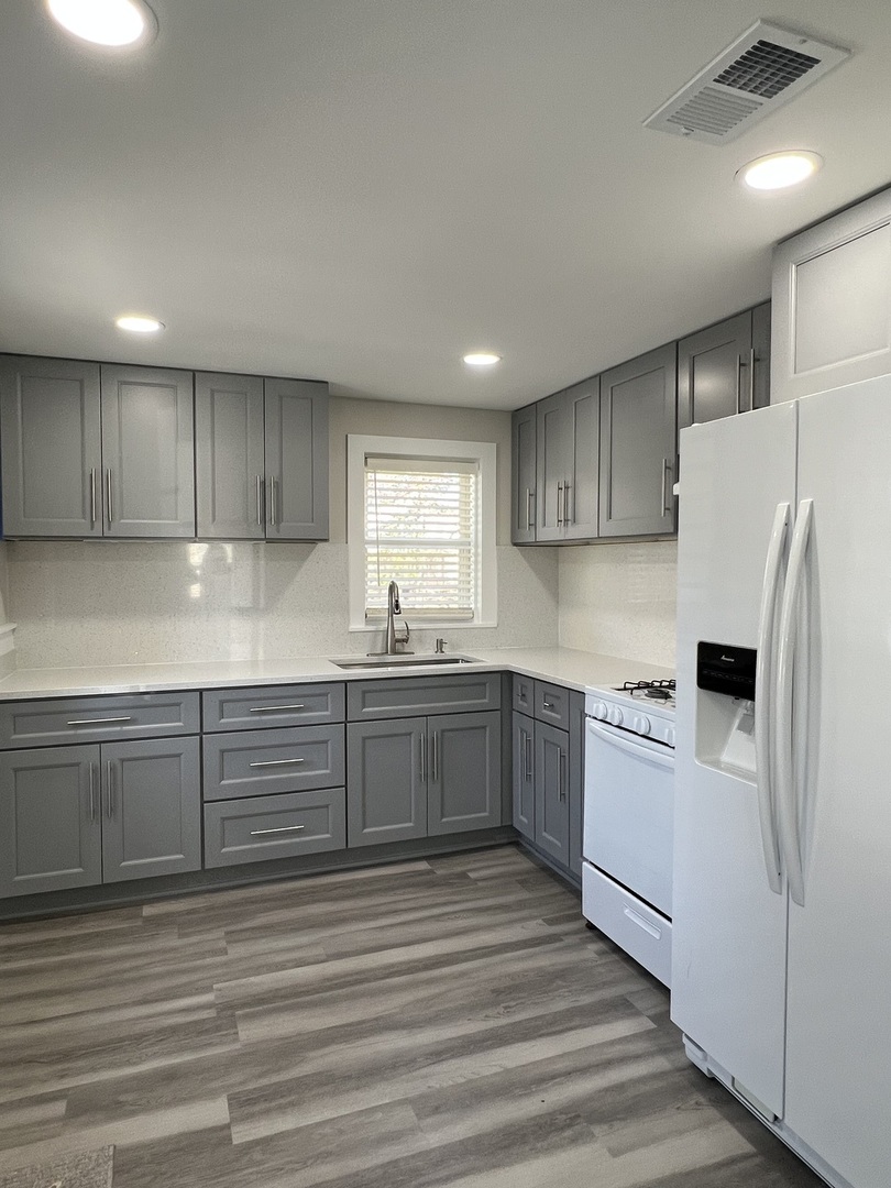 407 Abe Street Plano, IL 60545 - Photo 2 of 15 a kitchen with granite countertop a refrigerator sink and cabinets