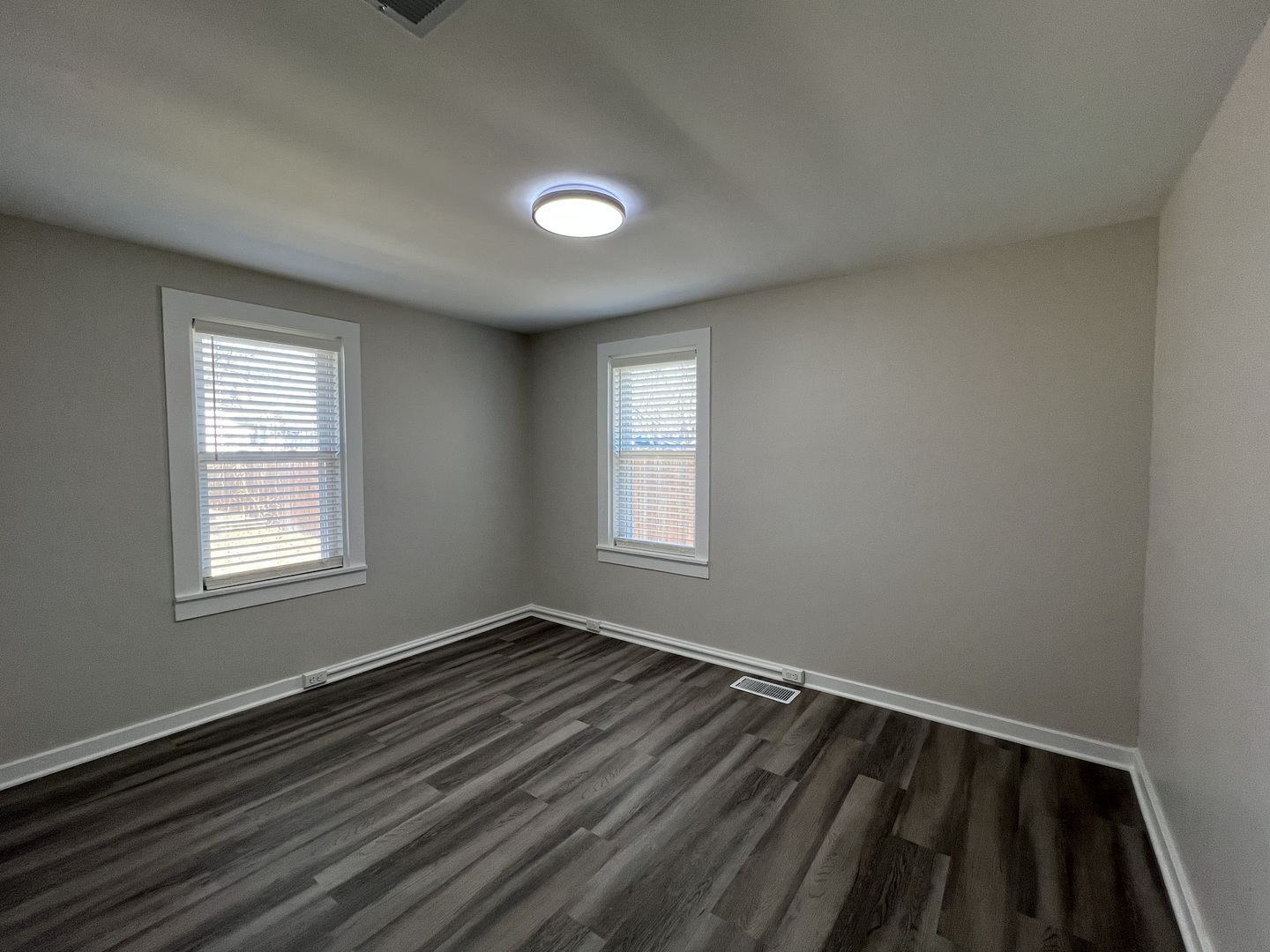 407 Abe Street Plano, IL 60545 - Photo 5 of 15 an empty room with wooden floor and windows