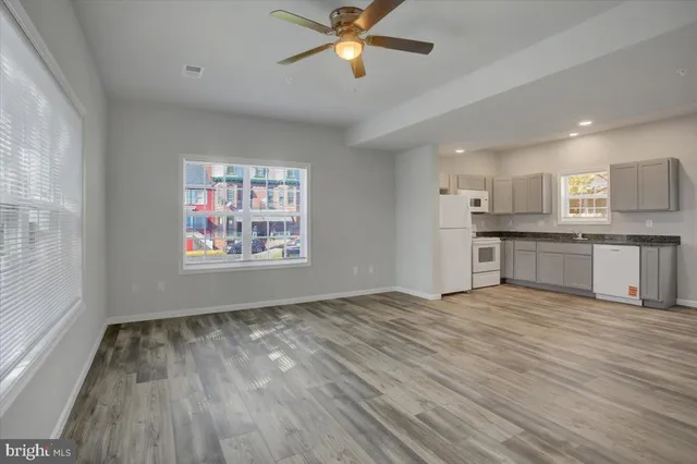 a view of a kitchen with a sink and dishwasher a refrigerator with wooden floor