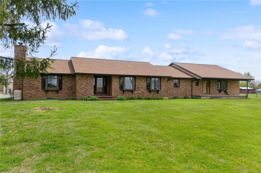 4971 Lackey Road Cedarville, OH 45314 - Photo 3 of 79 This ranch-style home features classic brick construction, a prominent chimney, and a spacious green lawn.