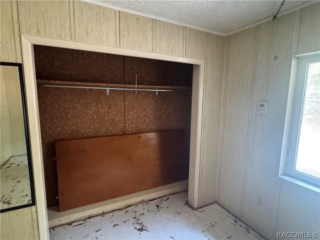 3953 South Fernpark Terrace Inverness, FL 34452 - Photo 13 of 16 a view of a refrigerator in kitchen and an empty room with wooden floor