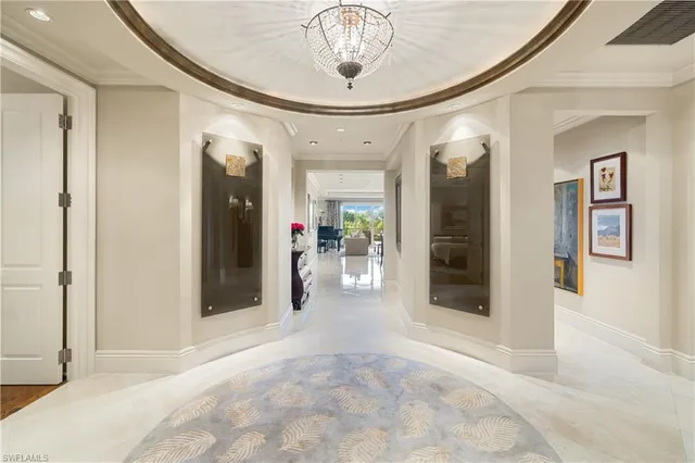 a view of a hallway with wooden floor and a chandelier