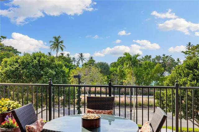 a view of a balcony with two chairs and a potted plant