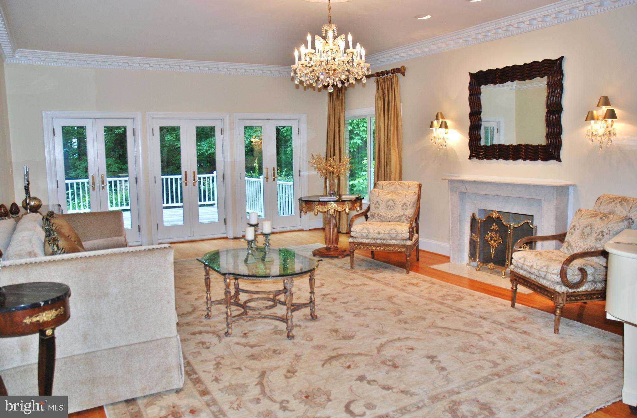 11548 Springridge Road Potomac, MD 20854 - Photo 9 of 30 a living room with furniture a fireplace and a chandelier