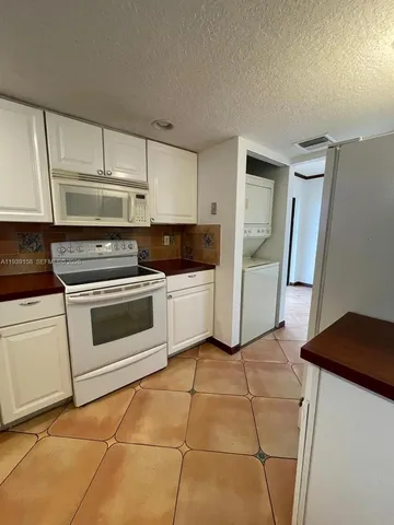 a kitchen with cabinets and white appliances