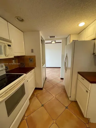 a kitchen with a refrigerator and a stove top oven