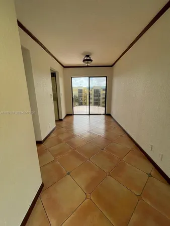 a view of a livingroom with an empty space and a window