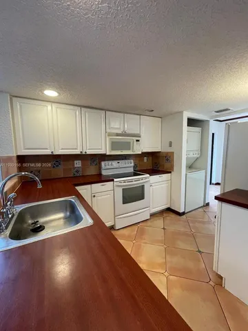 a kitchen with a sink a stove and cabinets