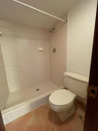 a white toilet sitting next to a bath tub and a shower