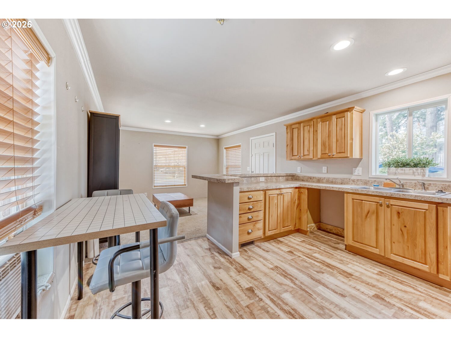4264 Southeast 122nd Avenue, Unit 13 Portland, OR 97236 - Photo 15 of 30 a open kitchen with granite countertop a stove a sink dishwasher a dining table and chairs with wooden floor