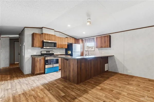 a kitchen with stainless steel appliances granite countertop a refrigerator and a stove top oven
