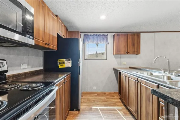 a kitchen with stainless steel appliances granite countertop a stove a sink and a refrigerator