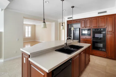 a kitchen with stainless steel appliances granite countertop a sink a stove and a refrigerator