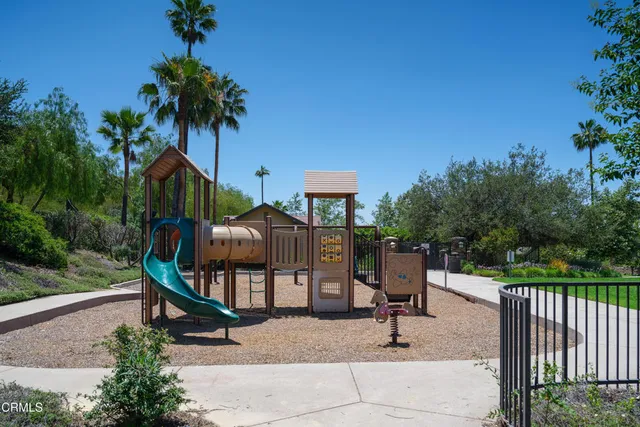 a view of a park with a bench and potted plants