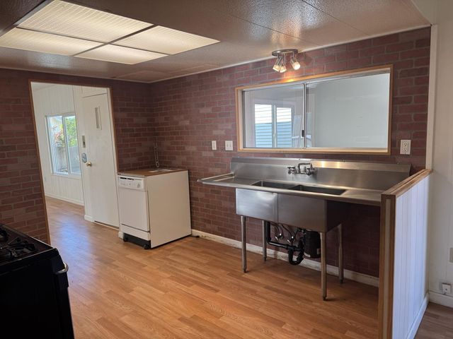 a kitchen with a sink cabinets and wooden floor