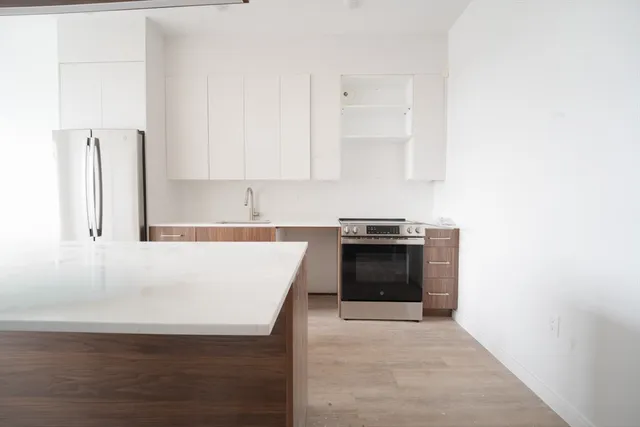 a large white kitchen with granite countertop a stove top oven a sink and dishwasher