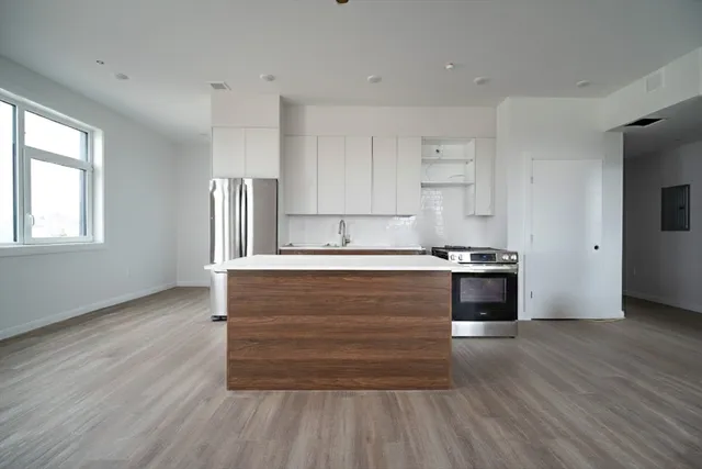 a kitchen with granite countertop wooden floors and wide window