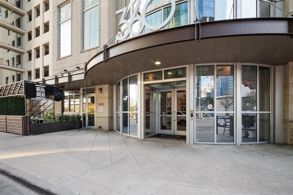360 Nueces Street, Unit 2005 Austin, TX 78701 - Photo 31 of 35 The property features a building with a curved entrance facade, large glass doors, and expansive windows