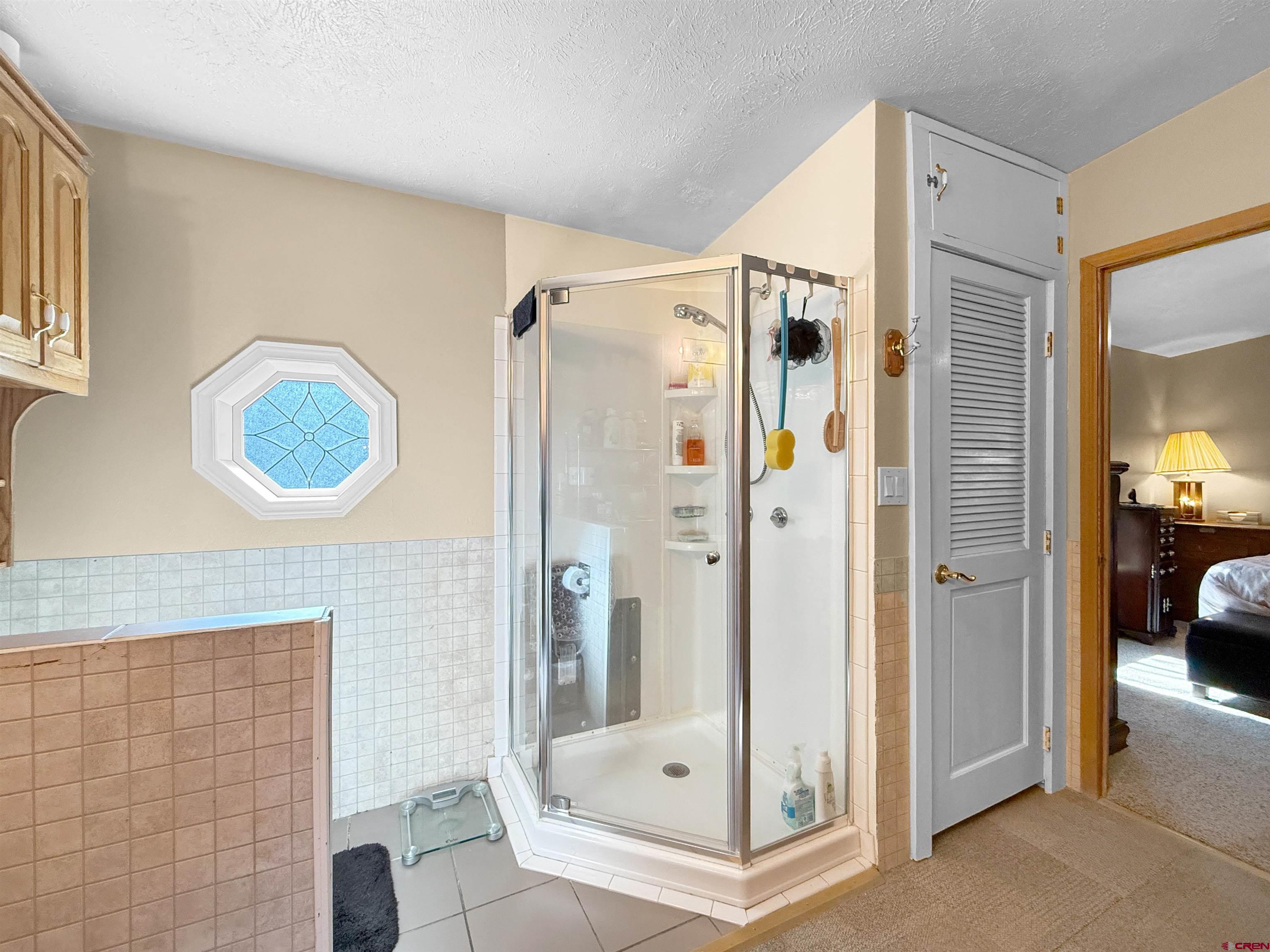 18311 2550th Road Cedaredge, CO 81413 - Photo 14 of 29 a bathroom with a glass shower door and a sink