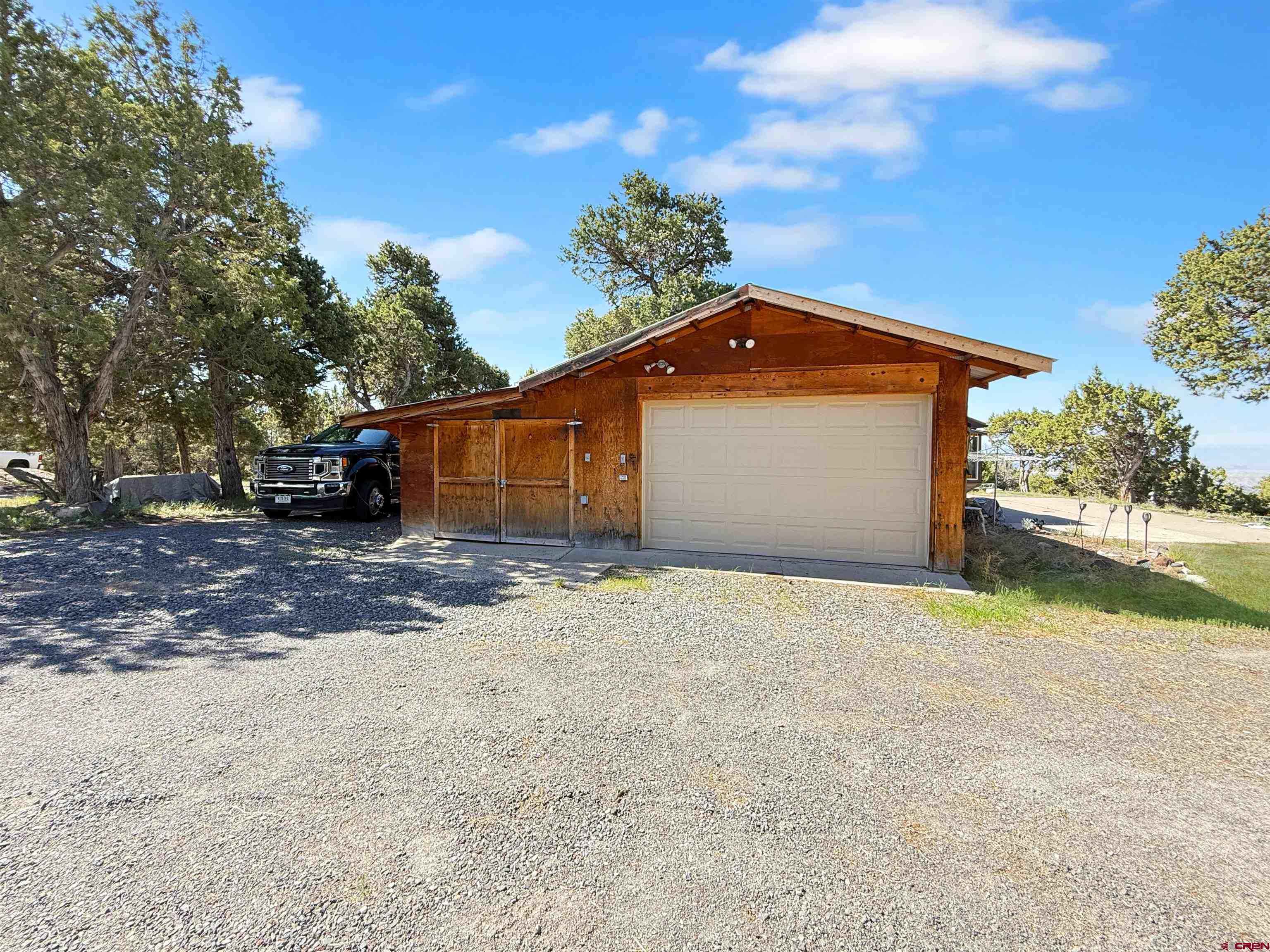18311 2550th Road Cedaredge, CO 81413 - Photo 20 of 29 a front view of a house with a yard and garage