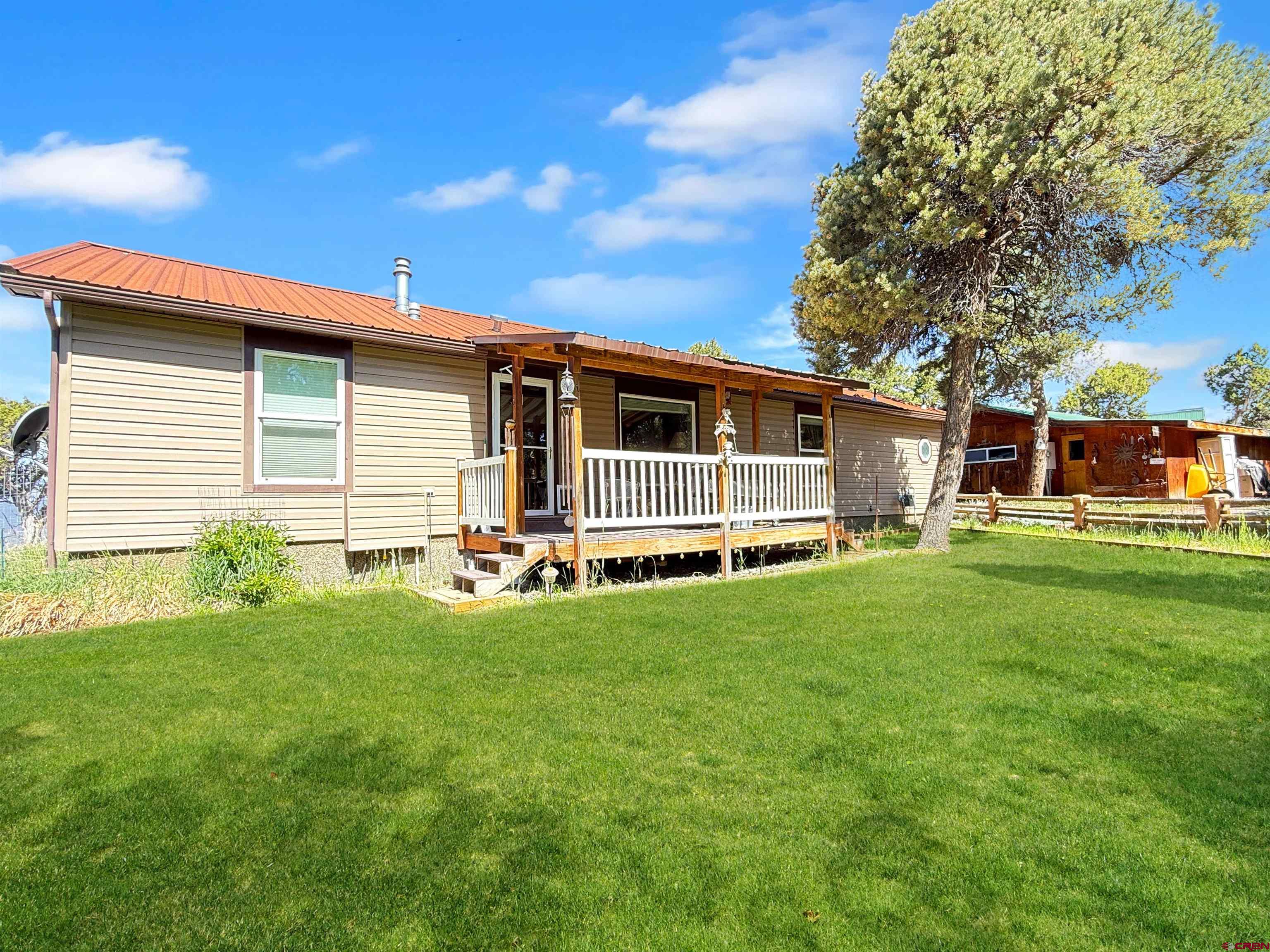 18311 2550th Road Cedaredge, CO 81413 - Photo 2 of 29 a front view of house with yard and green space