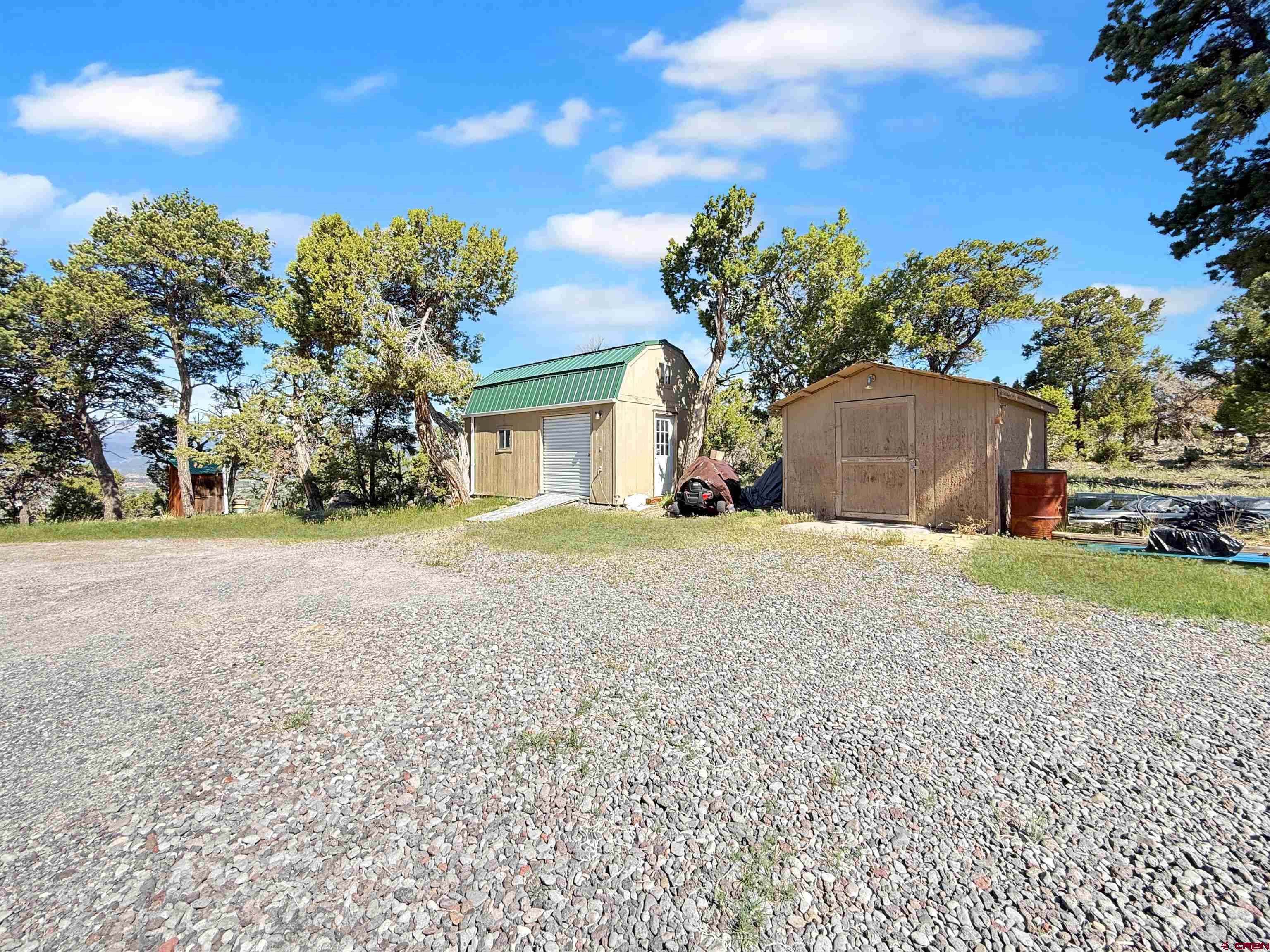 18311 2550th Road Cedaredge, CO 81413 - Photo 22 of 29 a front view of a house with a yard and a garage