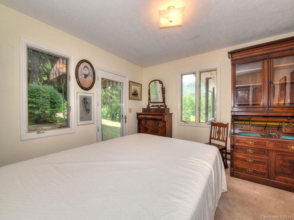 4607 Old Clyde Road Clyde, NC 28721 - Photo 11 of 24 a bedroom with a bed and a large mirror on the dresser