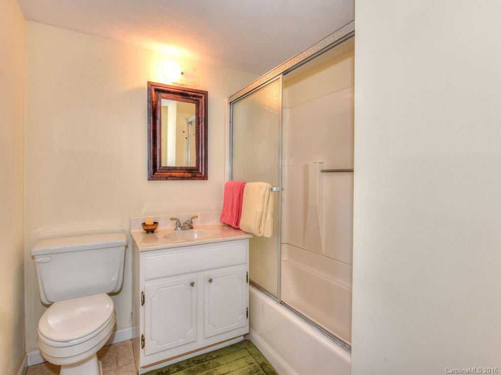 4607 Old Clyde Road Clyde, NC 28721 - Photo 13 of 24 a bathroom with a toilet sink vanity and mirror