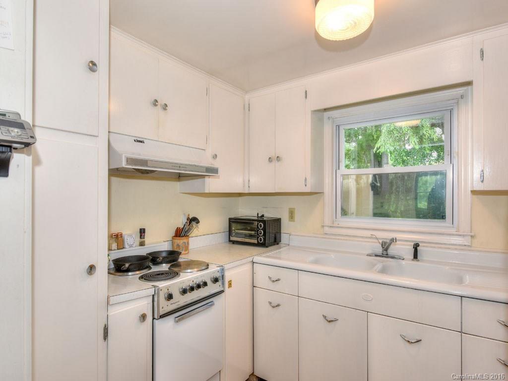 4607 Old Clyde Road Clyde, NC 28721 - Photo 8 of 24 a kitchen with stainless steel appliances granite countertop white cabinets a sink a stove and a window