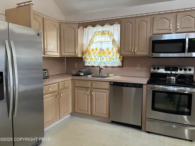 a kitchen with white cabinets stainless steel appliances and sink