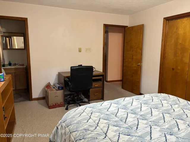 a bedroom with a bed and a computer on a table