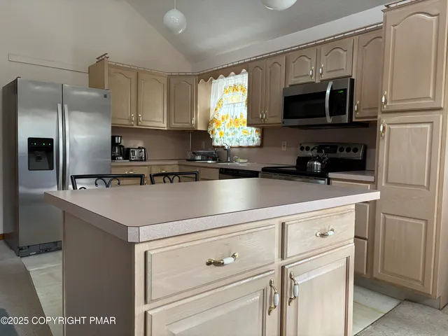 a kitchen with appliances a sink and cabinets