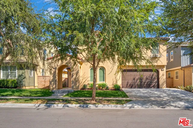 a view of a house with a yard and large trees