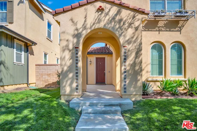 a view of a house with brick walls and a small yard